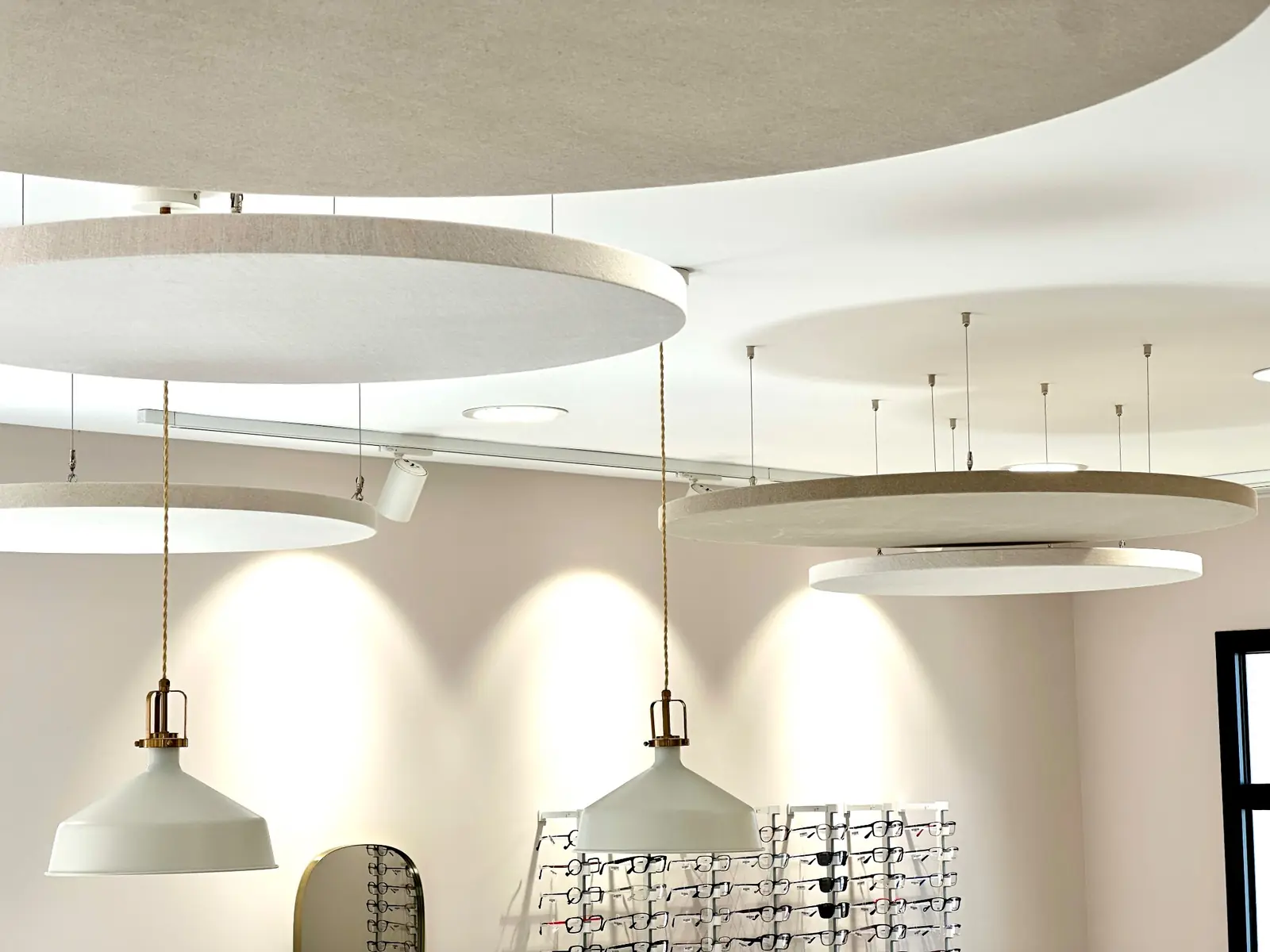 Suspensions acoustiques circulaires installées dans un magasin d’optique