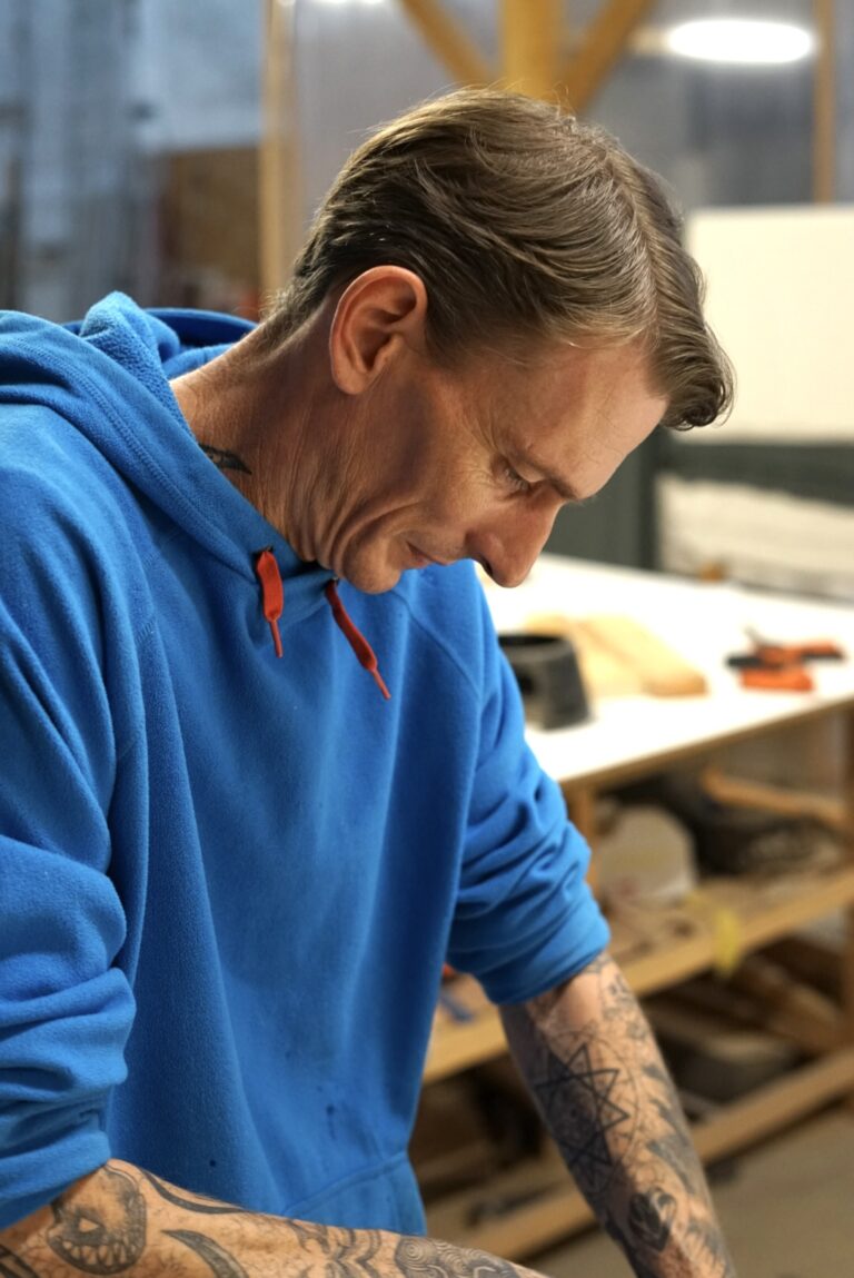 Ian, concentré sur une opération de fabrication à l’établi dans l’atelier LINA.